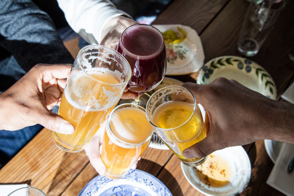 Cheers with beer at Paradise Grapevine, which is on our list of the best patios in Toronto